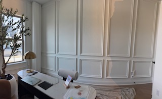 Finished office wall paneling with desk and decor
