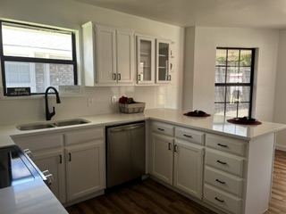 Finished kitchen with white cabinets and black hardware