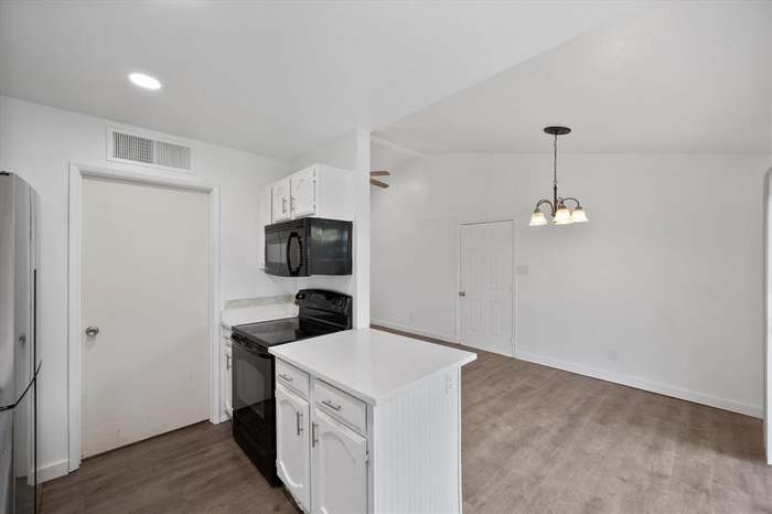 Finished kitchen with dark cabinets and black appliances