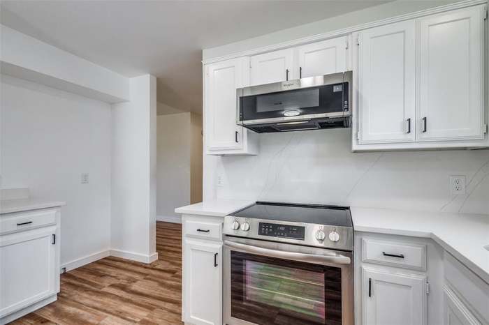 Finished kitchen remodel with white cabinets and stainless appliances