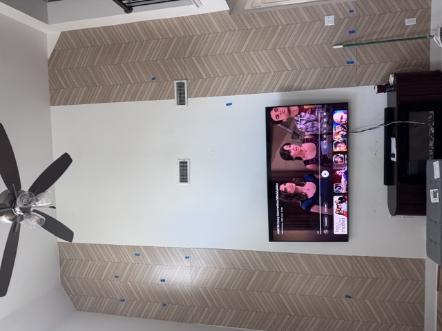 Chevron accent wall installation in progress with scaffolding