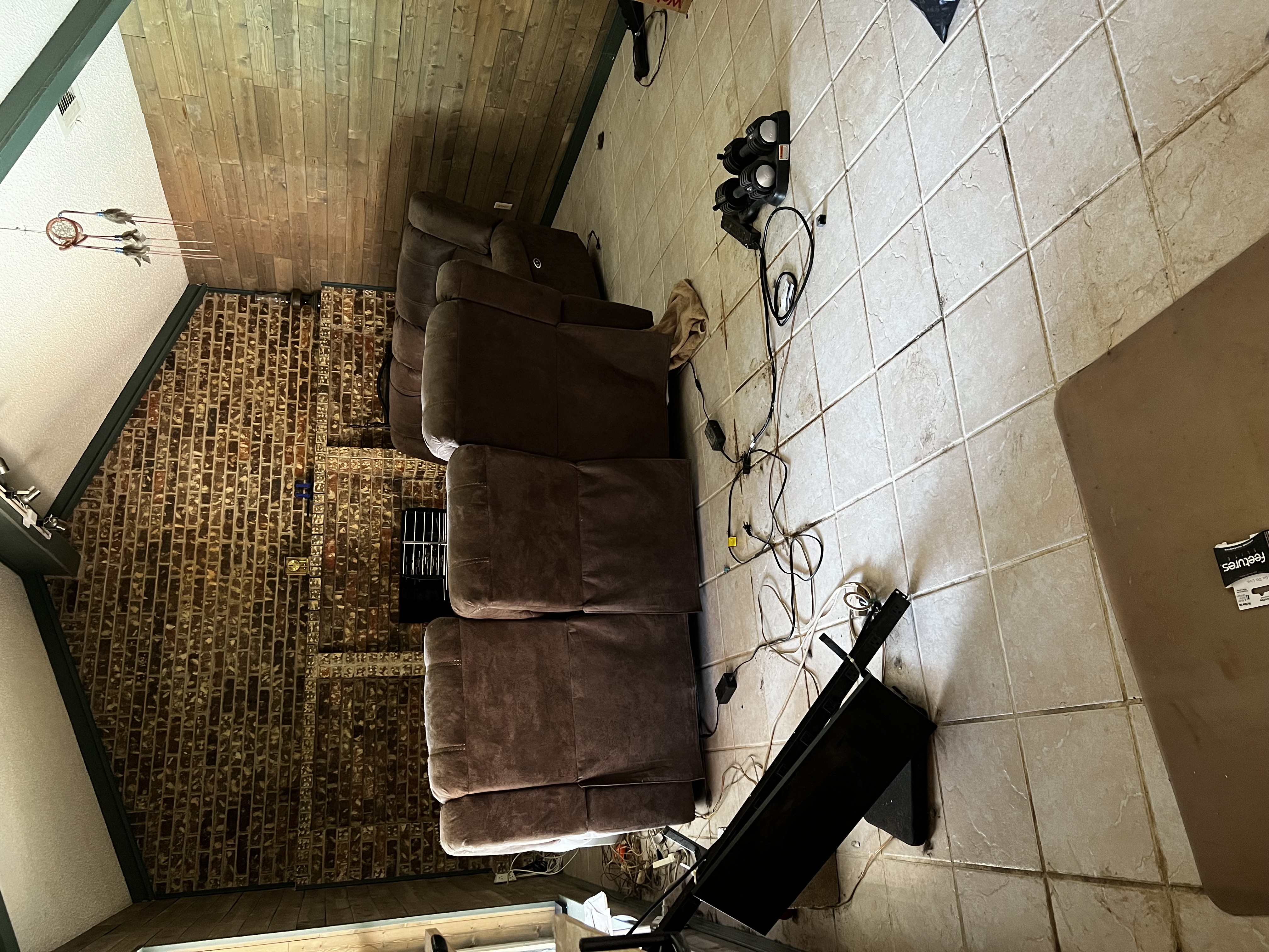 Dated living room with brick fireplace and tile floor before remodel