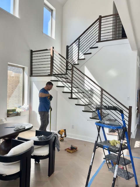 Worker installing a stair railing
